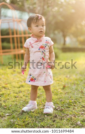 Cute asian baby girl with Chinese dress play in playground
