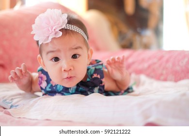 Cute Asian Baby Girl On The Bed.