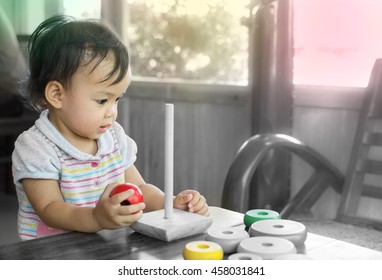 Cute asian baby play wood toy on black and white background,beautiful color make from filter effect