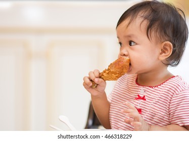 Cute Asian Baby Sit On Hight Chair And Eating Big Fried Chicken By Herself