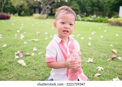 Cute Asian Boy Child Drinking Pure Water From Plastic Water Bottle On Nature In The Park, Little Kid Drink Water After Exercise, Sitting And Relaxing On Backyard