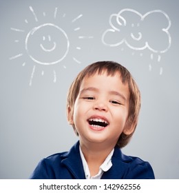 Cute Asian Boy Laughing With Children's Drawings Above His Head.