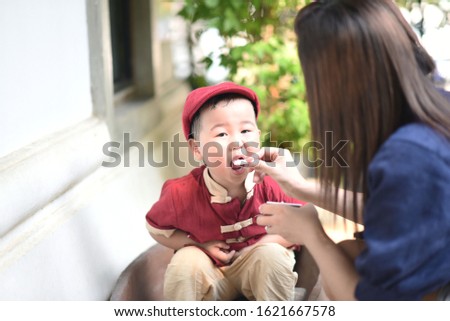 cute asian boy and mother eat icecream