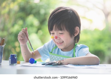 Cute Asian Child Enjoying Arts And Crafts Painting With His Hands