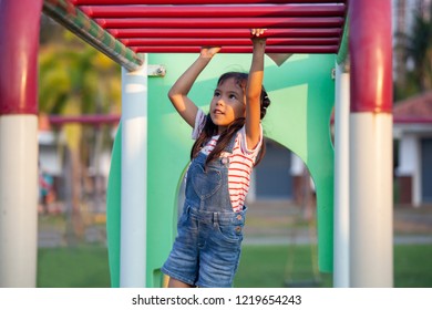 Cute asian child girl hang the bar by her hand to exercise in the playground - Powered by Shutterstock