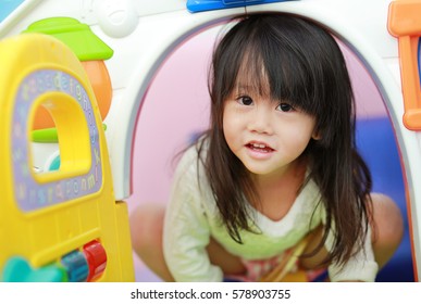 Cute Asian Child Girl Playing With Window Toy Playhouse In Playground.