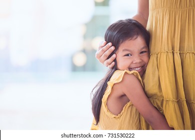 Cute Asian Child Girl Smiling And Hugging Her Mother Leg In Vintage Color Tone