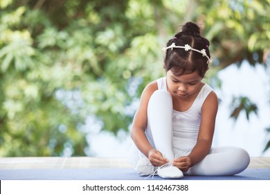 Cute Asian Child Girl Tying On Feet Point Shoes Preparing For Practicing A Ballet