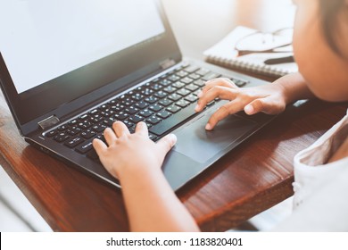 Cute asian child girl using and playing on laptop in the cafe - Powered by Shutterstock