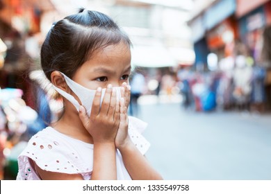 Cute Asian Child Girl Wearing Protection Mask To Against Air Smog Pollution With PM 2.5 In The City