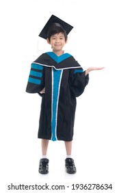 Cute Asian Child In Graduation Gown Show Something Copy Space.Commercial Advertisement. Promotion Concept. Promoting Product For Kids.