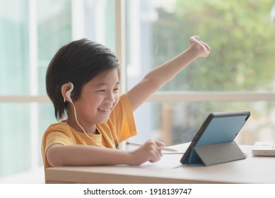 Cute Asian Child Learning Class Study Online With Video Call From Tablet At Home .Social Distancing  Concept