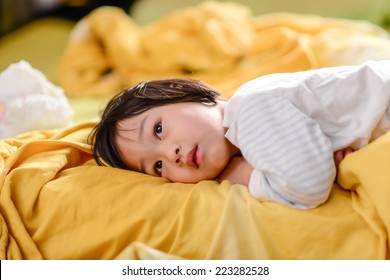 Cute Asian Child Lying On Bed.