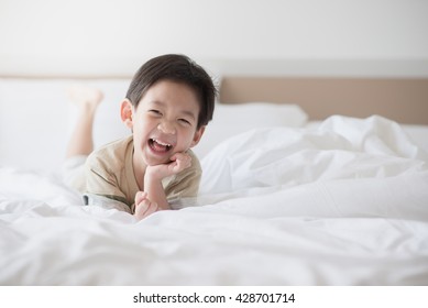 Cute Asian Child Lying On White Bed