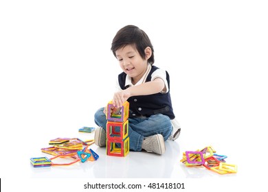 Cute Asian Child Playing With Lots Of Colorful Magnet Plastic Blocks Kit On White Background Isolated