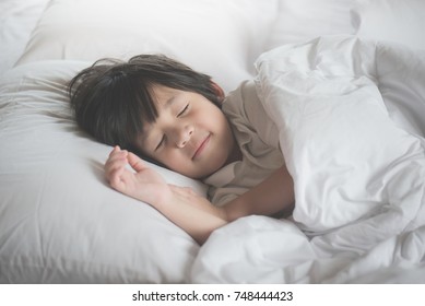 Cute Asian Child Sleeping On White Bed