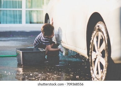 Cute asian child washing a car on summer day - Powered by Shutterstock