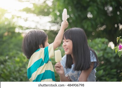 Cute Asian children eating japanese ice cream outdoors