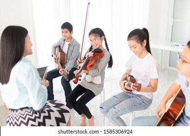 Cute Asian Children Holding Violin On Her Shoulder And Play Violin, She Show Violin Skill And Present Melody And Song To Teacher And Friends, Asian Children Group In Musical Training Time