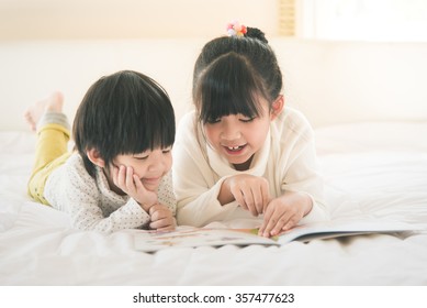 Cute Asian Children Reading Book On White Bed,vintage Filter