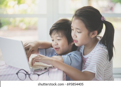 Cute Asian children using tablet together