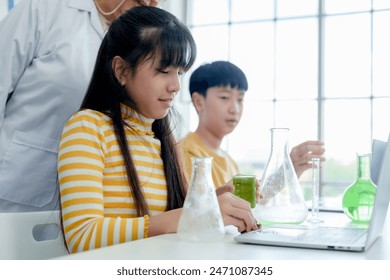 Cute Asian elementary school student is experimenting with mixing colors in science test tube with classmates. Learn to experiment in school laboratory. There will be teachers nearby ready give advice - Powered by Shutterstock