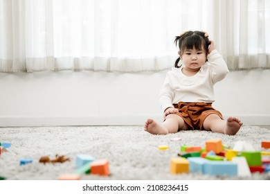 Cute Asian girl plays with wooden puzzles to enhance her age-appropriate systemic thinking skills and imagination. Concept of education and brain development of children. - Shutterstock ID 2108236415