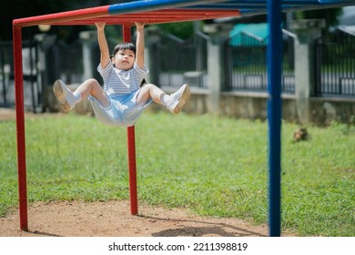 Cute Asian Girl Smile Play Climb The Bar On School Or Kindergarten Yard Or Playground. Healthy Activity Children. Little Girl Climbing Outdoors At Playground. Child Playing On Outdoor Playground.