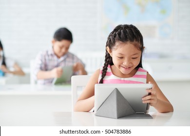 Cute Asian Girl Working On Tablet Computer In Class