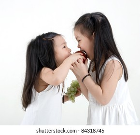 Cute Asian Girls Sharing An Apple