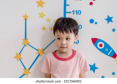 Cute Asian Kid Stand For Measure Height With Cute Cartoon. Soft Focus. Copy Space.