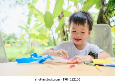 Cute Asian kindergarten boy coloring DIY tote bag with makers at home, Little kid enjoying doing arts and crafts project at home on nature, improve focus in child concept - Shutterstock ID 1984522106