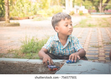 Cute asian little boy play toy in the park,vintage tone