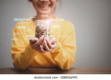 Cute Asian Little Child Girl Making Stacks Of Coins . Kid Saves Money For Future Education. Money, Finances, And People Concept