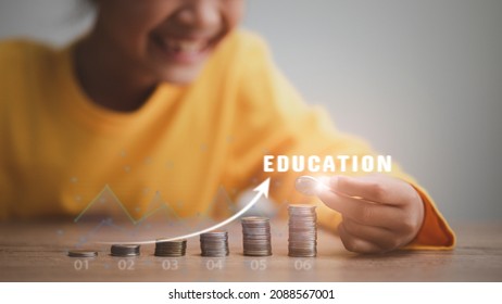 Cute Asian Little Child Girl Making Stacks Of Coins . Kid Saves Money For Future Education. Money, Finances, And People Concept