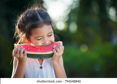 Cute Asian Little Child Girl Eating Watermelon Fresh Fruit In The Garden