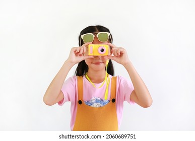 Cute Asian Little Girl Kid Taking Picture With Photo Camera Toy Isolated On White Background.