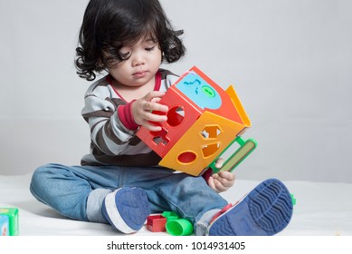 Cute asian little girl playing and learning different shape with a toy.