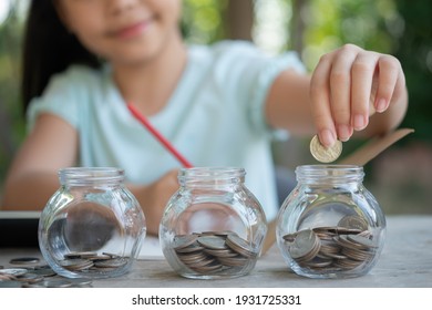 Cute asian little girl playing with coins making stacks of money,kid saving money into piggy bank, into glass jar. Child counting his saved coins, Children learning about for the future concept. - Shutterstock ID 1931725331