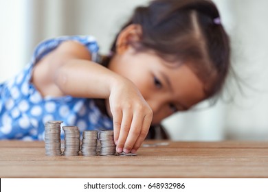 Cute Asian Little Girl Playing With Coins Making Stacks Of Money,kid Saving Money For The Future Concept