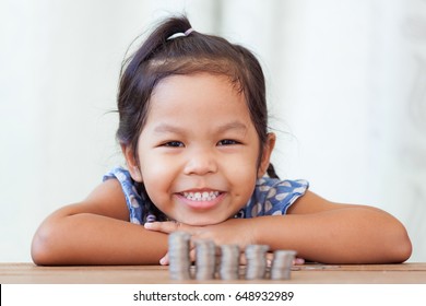 Cute Asian Little Girl Playing With Coins Making Stacks Of Money,kid Saving Money For The Future Concept