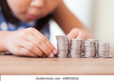 Cute Asian Little Girl Playing With Coins Making Stacks Of Money,kid Saving Money For The Future Concept