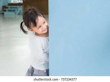 Cute Asian Little Girl Is Playing Hide And Seek With Funny Moment, Concept Of Learning By Playing For Child Development.