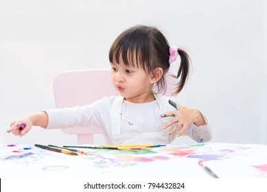 Cute Asian Little Girl Is Sitting And Talking Something, She Is Painting The Color On Hand And Stamp To The White Paper, Concept Of Art And Education For Kid.