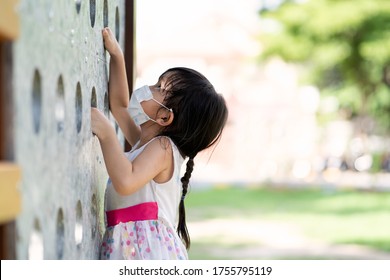 Cute Asian Little Girl Is Wear A Face Mask To Protect The Pm 2.5 And Covid 19 Virus Outbreak While Playing Outdoor In The Playground, Concept Of New Normal And Personal Healthcare And Hygiene For Kid.