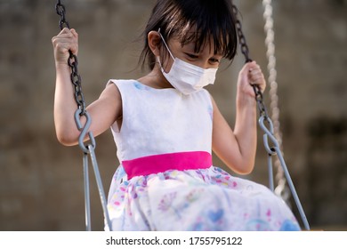 Cute Asian Little Girl Is Wear A Face Mask To Protect The Pm 2.5 And Covid 19 Virus Outbreak While Playing Outdoor In The Playground, Concept Of New Normal And Personal Healthcare And Hygiene For Kid.