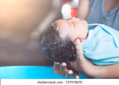 Cute Asian Newborn Baby Girl Take A Bath. Mom Cleaning Her Baby Hair.