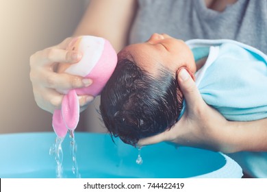 Cute Asian Newborn Baby Girl Take A Bath. Mom Cleaning Her Baby Hair With Sponge.