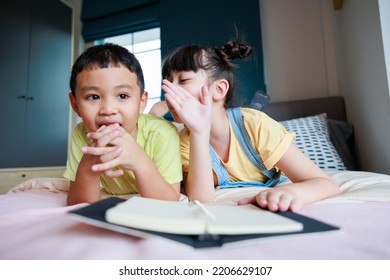 Cute Asian Older Sister Teach Brother Reading Book And Telling Funny Stories 