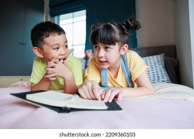 Cute Asian Older Sister Teach Brother Reading Book And Telling Funny Stories 